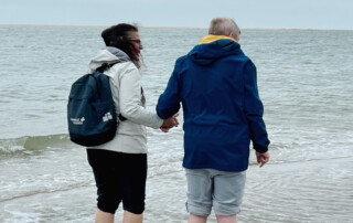 Zwei Personen laufen durchs Meer.