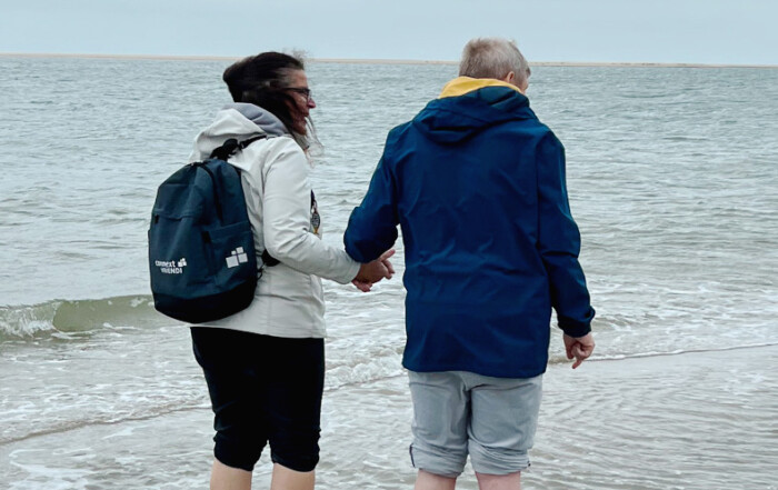 Zwei Personen laufen durchs Meer.
