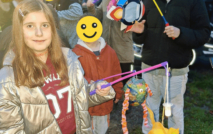 Mehrere Kinder zeigen ihre Laternen und stehen zusammen für ein Foto.