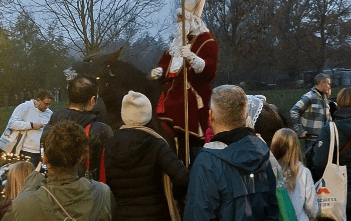 Mehrere Personen stehen um den St. Martin der auf seinem Pferd sitzt.