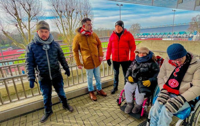 Ein Gruppenfoto der Bewohner und Bewohnerinnen vor dem Stadion.