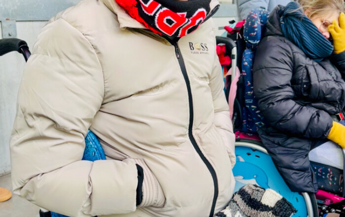 Ein Bewohner sitzt im Stadion und lächelt in die Kamera.