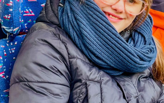 Ein Bewohner sitzt im Stadion und lächelt in die Kamera.