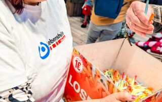 Eine Frau hält die Box mit den Losen in der Hand.