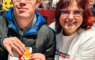 Zwei Personen halten ihr Los in die Kamera.