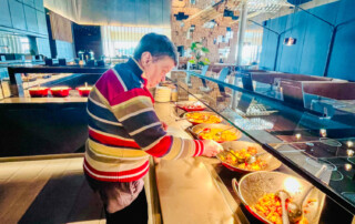 Eine Bewohnerin schaut sich das Buffet an.