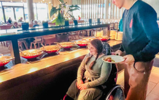 Ein Betreuer und eine Bewohnerin schauen sich das Buffet an.