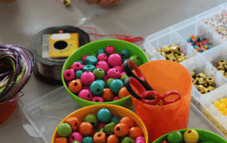 Ein Kind bastelt ein Perlenarmband.