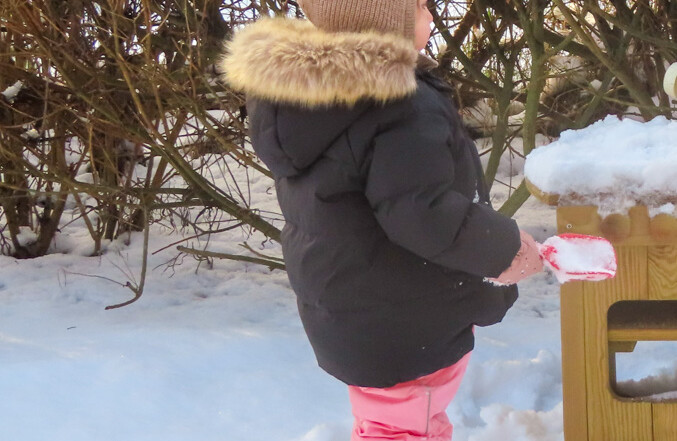 Ein Kind spielt im Schnee.