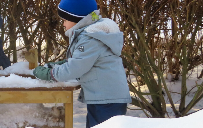 Ein Kind spielt im Schnee.