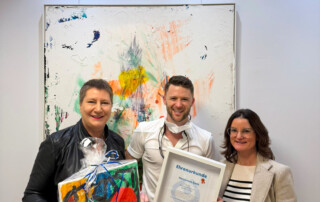 Ein Bild der Übergabe einer Ehrenurkunde von Gesine Eschenburg an Dr. Tim Graf aus dem Zahn-Ärzte-Team.