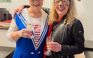 Ein Foto von zwei verkleideten die in die Kamera lächeln.