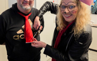 Eine Frau schneidet einem Mann die Krawatte ab.