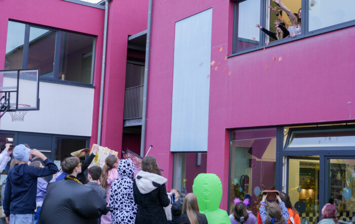 Aus dem Fenster werden Kamelle auf die Besucher geworfen