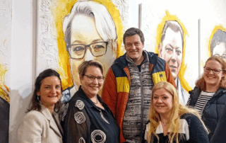 Ein Gruppenfoto vor dem Portrait.