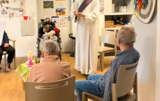 Der Priester spricht zu den Bewohnern