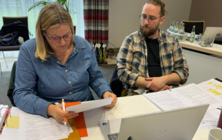 Eine Mitarbeiterin und ein Mitarbeiter tauschen sich aus.