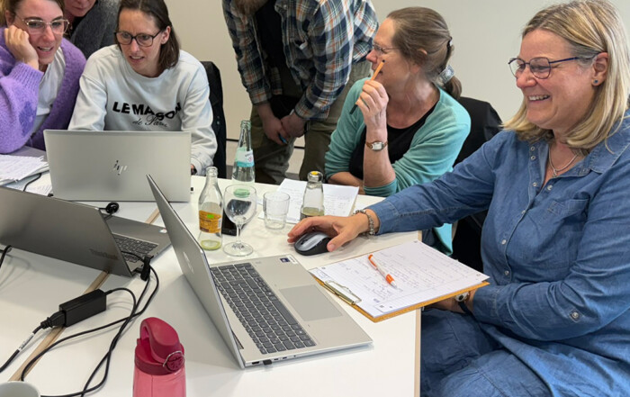 Die Gruppe arbeitet an ihren Laptops