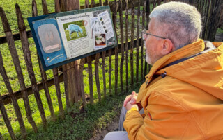 Ein Bewohner liest sich ein Infoschild durch.