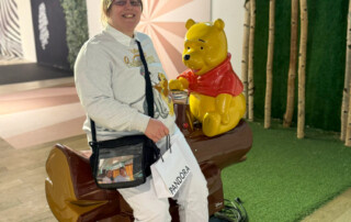 Eine Bewohnerin sitzt neben einer Winnie Puh Figur.