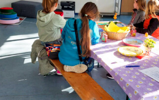 Vier Mädchen sitzen an einem Tisch und basteln.