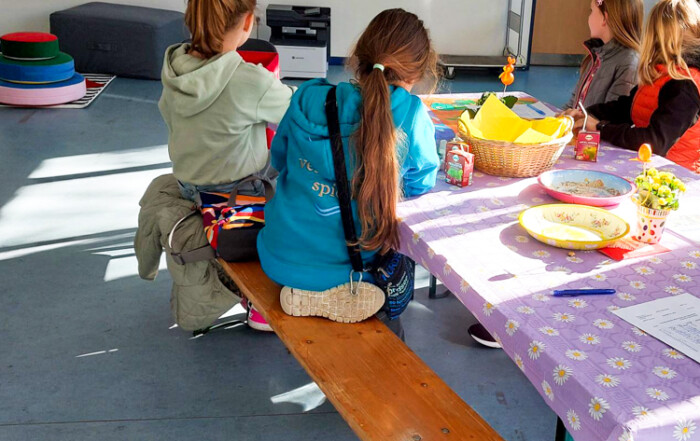 Vier Mädchen sitzen an einem Tisch und basteln.