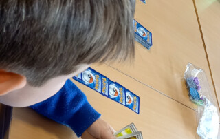 Ein Kind zeigt seine Kartensammlung.