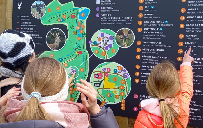 Kinder schauen sich den Plan des Wildparks an.