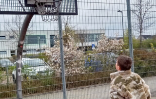 Ein Kind wirft einen Basketball in den Korb.