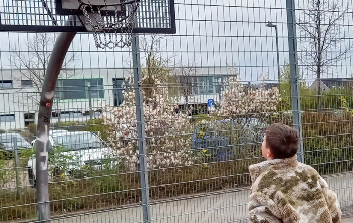 Ein Kind wirft einen Basketball in den Korb.