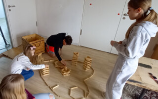 Mehrere Kinder bauen mit Holzklötzen.