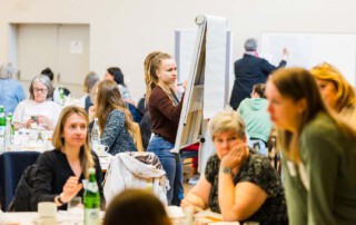 Eine Teilnehmende schreibt mit einem Stift Notizen auf das Whiteboard.