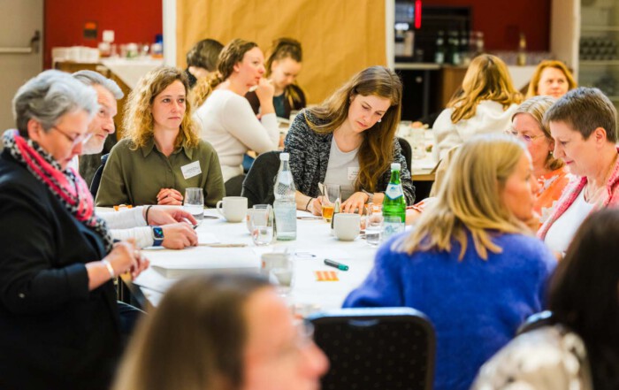 Eine Gruppe von Teilnehmenden arbeiten untereinander.