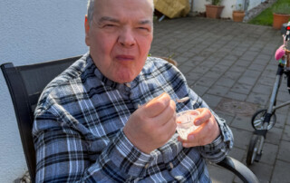 Ein Bewohner genießt sein Eis und schaut in die Kamera.