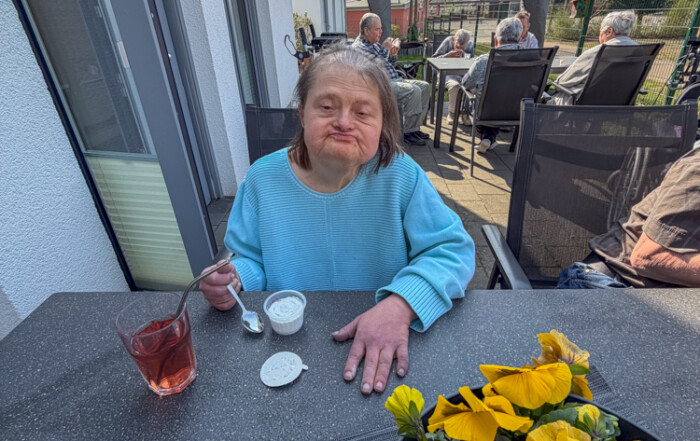 Eine Bewohnerin genießt ihr Eis und schaut in die Kamera.