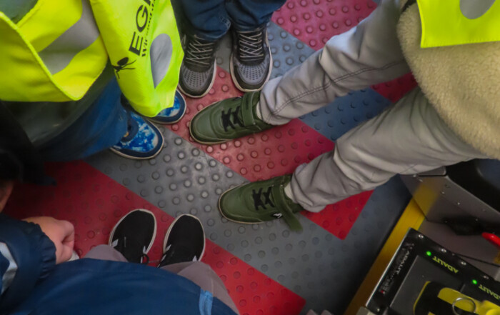 Ein Bild von den Kindern wie sie die Warnwesten anhaben und im Feuerwehr-Auto stehen.