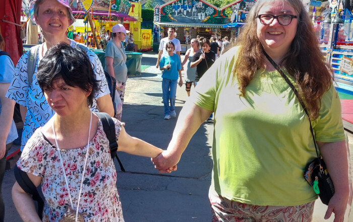 Drei Bewohnerinnen laufen durch die Kirmes.
