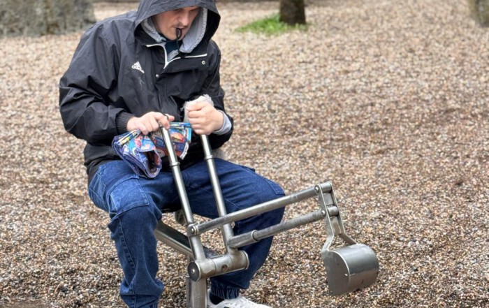 Ein Bewohner benutzt ein Spielzeugbagger und gräbt damit Kies um.