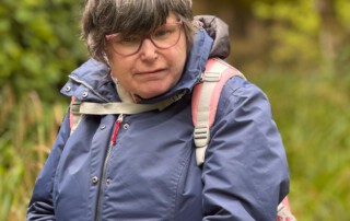 Eine Frau schaut interessiert die Tiere im Zoo an.