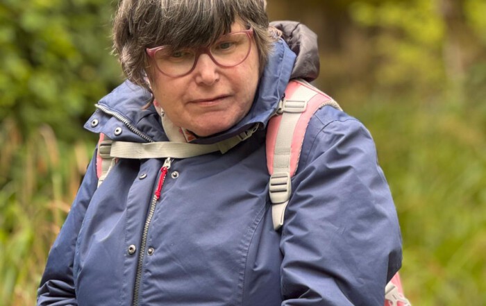 Eine Frau schaut interessiert die Tiere im Zoo an.