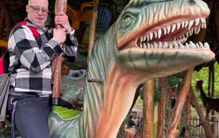 Ein Bewohner fährt im Karussell auf einem Dinosaurier mit.