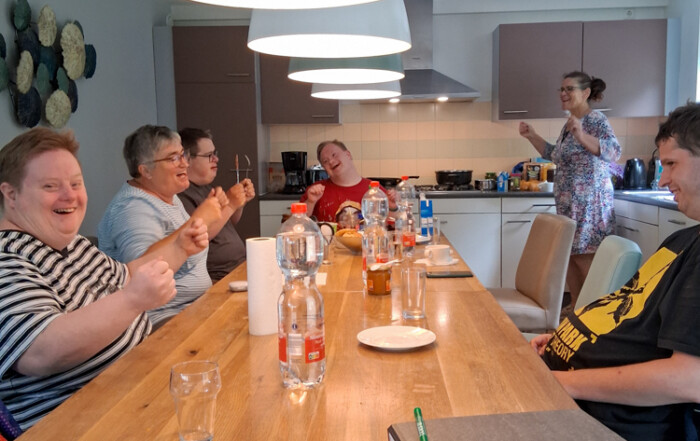 Die ganze Gruppe sitzt am Tisch und isst gemeinsam