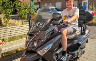Ein Junge sitzt auf einem Polizei-Motorrad.