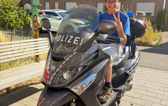 Ein Junge sitzt auf einem Polizei-Motorrad.