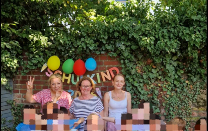 Ein Gruppenfoto der Erzieherinnen mit den Kindern.