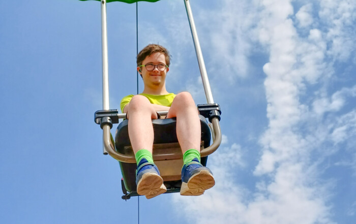 Ein Junge schaut aus einem Karussel raus in die Kamera.