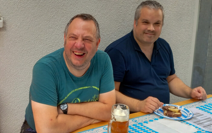 Zwei Gäste lächeln in die Kamera.