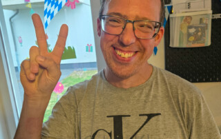 Ein Bild von einem Bewohner der in die Kamera lächelt.