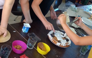Mehrere Mädchen dekorieren eine Torte.