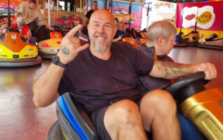 Ein Bewohner und eine Betreuerin sind auf dem Auto-Scooter.